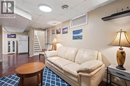 Finished lower level featuring recessed lighting, a drop ceiling, wood-finish flooring, and a staircase with painted risers and dark treads - 30 Heatherwood Place, Kitchener, ON - Indoor Photo Showing Living Room