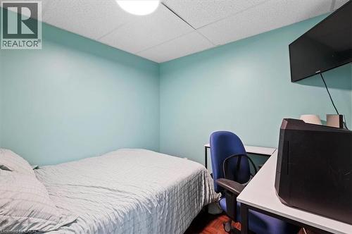 Interior room featuring light blue painted walls, wood-finish flooring, and a white acoustical tile ceiling - 30 Heatherwood Place, Kitchener, ON - Indoor Photo Showing Bedroom