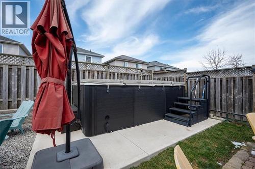 Backyard featuring a dark-toned swim spa with entry steps, set on a concrete pad - 30 Heatherwood Place, Kitchener, ON - Outdoor With Exterior