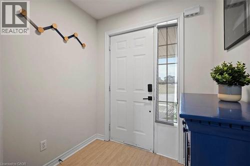 Entryway featuring a white paneled door with matte black hardware, sidelight window, wood-finish flooring, and light-toned walls - 30 Heatherwood Place, Kitchener, ON - Indoor Photo Showing Other Room