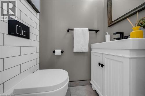 Modern bathroom featuring subway tile walls, a white vanity with paneled doors, and a rectangular undermount sink - 26 Peachtree Crescent, Cambridge, ON - Indoor Photo Showing Bathroom