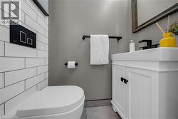 Modern bathroom featuring subway tile walls, a white vanity with paneled doors, and a rectangular undermount sink - 