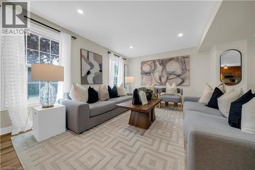 Recessed lighting illuminates this living space featuring light-toned wall finishes and wood-finish flooring - 26 Peachtree Crescent, Cambridge, ON - Indoor Photo Showing Living Room