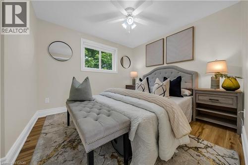 Bedroom featuring neutral wall tones, wood-finish flooring, a white window frame, and a ceiling fan with integrated lighting - 26 Peachtree Crescent, Cambridge, ON - Indoor Photo Showing Bedroom