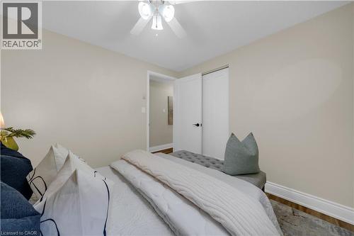 Bedroom featuring light neutral wall paint, wood-finish flooring, white baseboards, and a white ceiling fan with integrated lighting - 26 Peachtree Crescent, Cambridge, ON - Indoor Photo Showing Bedroom