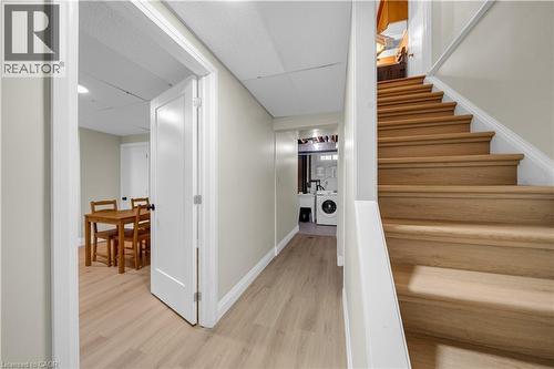 Wood-finish flooring throughout the hallway and room, complemented by a white paneled door - 26 Peachtree Crescent, Cambridge, ON - Indoor Photo Showing Other Room