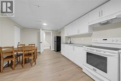Kitchen area featuring a white electric range, black refrigerator, and a stainless steel sink - 