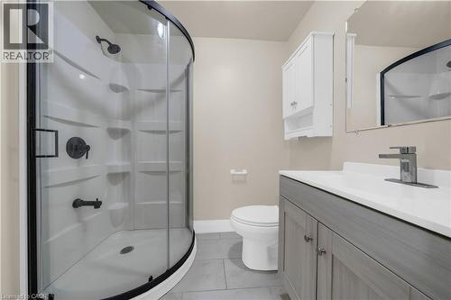 Bathroom featuring a curved glass shower enclosure with black trim, a gray wood-finish vanity with a white countertop, and a coordinating wall-mounted storage cabinet - 26 Peachtree Crescent, Cambridge, ON - Indoor Photo Showing Bathroom