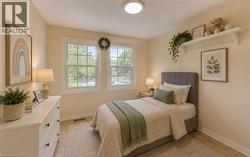 Bedroom featuring two windows, and a ceiling-mounted light fixture. Photo Virtually Staged. - 