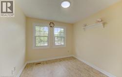 Spacious room featuring two large windows with white trim &  light-colored walls, - 