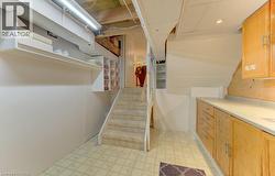 Carpeted staircase with built-in shelving and wood-finish cabinetry featuring a light-toned countertop - 