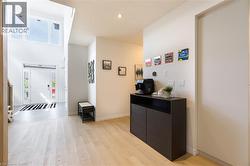 Two-story entryway featuring a white door with sidelights, transom window, and light wood-finish flooring - 