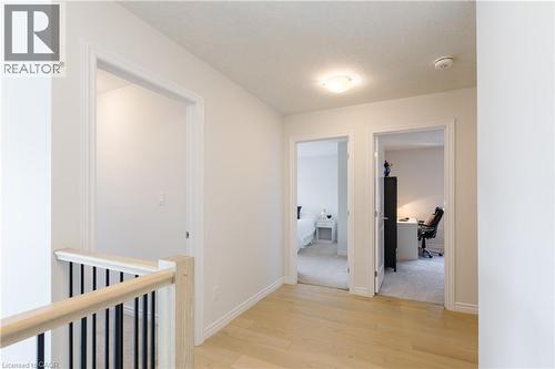 Second-story hallway featuring light wood-finish flooring, white walls, white trim, and a contemporary flush-mount ceiling light - 581 Doonwoods Crescent, Kitchener, ON - Indoor