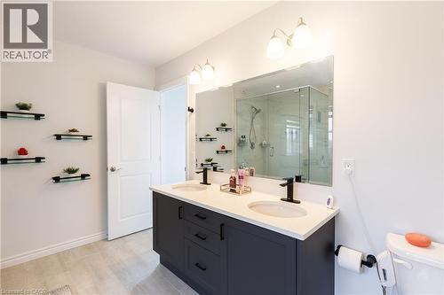 Double vanity with stone-finish countertop, undermount sinks, and matte black fixtures - 581 Doonwoods Crescent, Kitchener, ON - Indoor Photo Showing Bathroom