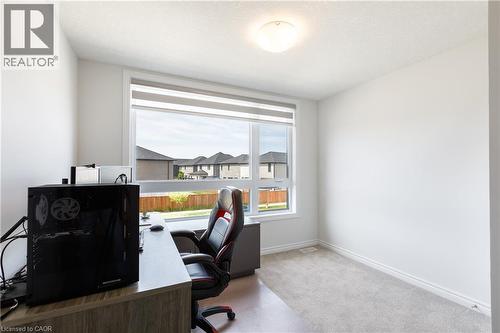 Bright room featuring a large window with roller shades, light grey carpet, white baseboards, and a flush mount ceiling light - 581 Doonwoods Crescent, Kitchener, ON - Indoor Photo Showing Office