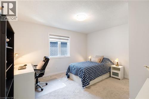 Light-filled room featuring neutral wall tones, textured carpeting, a window with horizontal blinds, and a ceiling-mounted light fixture - 581 Doonwoods Crescent, Kitchener, ON - Indoor Photo Showing Bedroom