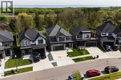 Contemporary residential street featuring multiple homes with dark shingle roofs - 