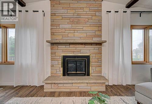 Stone fireplace featuring a hearth, mantel, and black-framed firebox - 128 Pollock Avenue, Cambridge, ON - Indoor Photo Showing Living Room With Fireplace