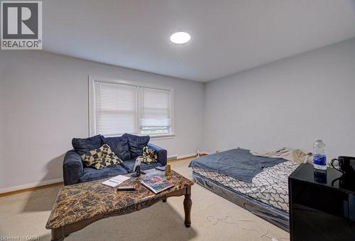 Carpeted room featuring a double window with blinds, white walls, and a ceiling-mounted light fixture - 128 Pollock Avenue, Cambridge, ON - Indoor