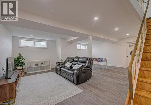Spacious finished basement featuring recessed lighting, light wood-finish flooring, and multiple windows - 128 Pollock Avenue, Cambridge, ON - Indoor Photo Showing Basement