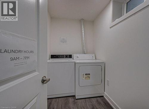 Dedicated laundry area featuring a white washer and dryer pair, wood-finish flooring, and an elevated window - 128 Pollock Avenue, Cambridge, ON - Indoor Photo Showing Laundry Room