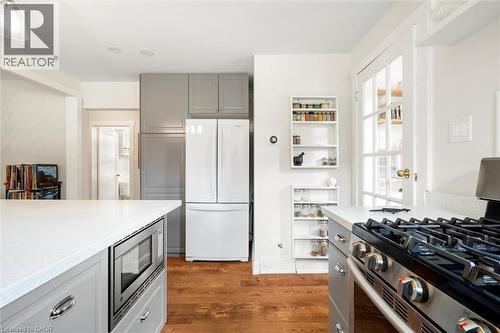 Modern kitchen featuring wood-finish flooring, white countertops, and contemporary gray cabinetry - 6295 Guelph Line, Burlington, ON - Indoor Photo Showing Kitchen With Upgraded Kitchen
