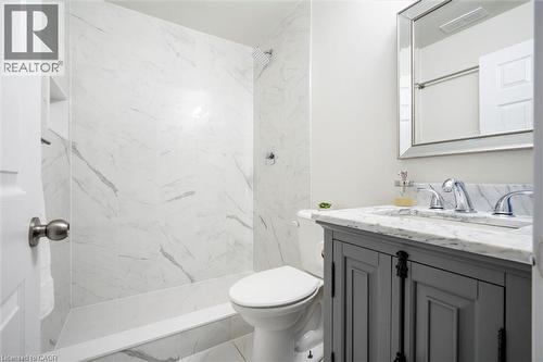 Bathroom featuring a white marble-look shower surround with a built-in niche, a white bathtub, and a toilet - 6295 Guelph Line, Burlington, ON - Indoor Photo Showing Bathroom