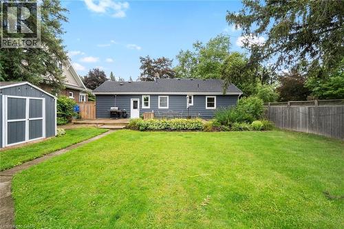 Expansive green lawn with a concrete pathway, a detached storage shed, a wooden deck, and mature perimeter trees - 6295 Guelph Line, Burlington, ON - Outdoor