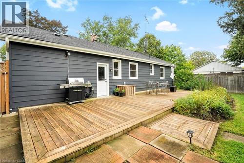 Rear exterior featuring a multi-level wood deck, dark gray horizontal siding, white trim windows, and a white exterior door - 6295 Guelph Line, Burlington, ON - Outdoor With Exterior