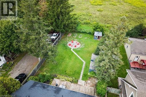 Expansive backyard featuring a central fire pit area with seating, a pathway, a shed, and mature perimeter trees - 6295 Guelph Line, Burlington, ON - Outdoor