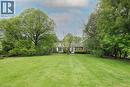 Expansive green lawn with mature trees and a brick-sided residence featuring white trim and multiple windows - 2023 Coronation Boulevard, Cambridge, ON  - Outdoor 