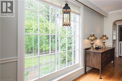 Large multi-pane window with white trim, light-toned wall paint, decorative chair rail, archway, and wood flooring - 2023 Coronation Boulevard, Cambridge, ON - Indoor Photo Showing Other Room