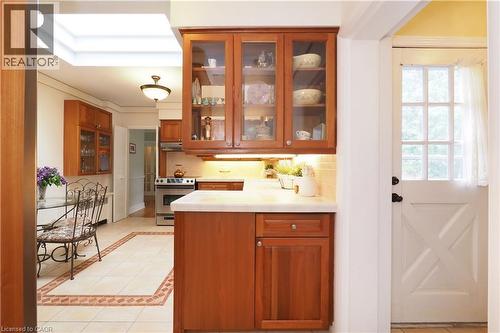 Kitchen featuring wood cabinetry with glass fronts, light-toned countertops, and an integrated stainless steel range - 2023 Coronation Boulevard, Cambridge, ON - Indoor Photo Showing Kitchen