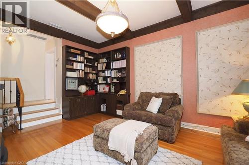 Room featuring corner built-in shelving, wood-finish flooring, exposed ceiling beams, and a semi-flush mount light fixture - 2023 Coronation Boulevard, Cambridge, ON - Indoor Photo Showing Living Room