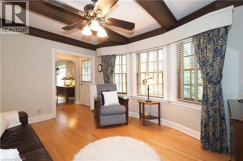 Warm and inviting room featuring wood-finish flooring, a ceiling fan with light fixture, and exposed ceiling beams - 2023 Coronation Boulevard, Cambridge, ON - Indoor