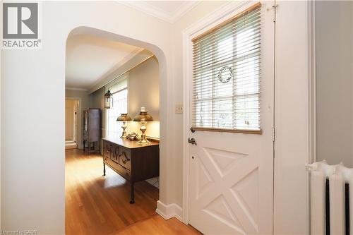 Entryway featuring a white paneled door with window blinds, hardwood flooring, an arched doorway, and crown molding - 2023 Coronation Boulevard, Cambridge, ON - Indoor Photo Showing Other Room