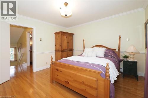 Warm-toned wood-finish flooring complements the two-tone wall treatment with chair rail detailing - 2023 Coronation Boulevard, Cambridge, ON - Indoor Photo Showing Bedroom