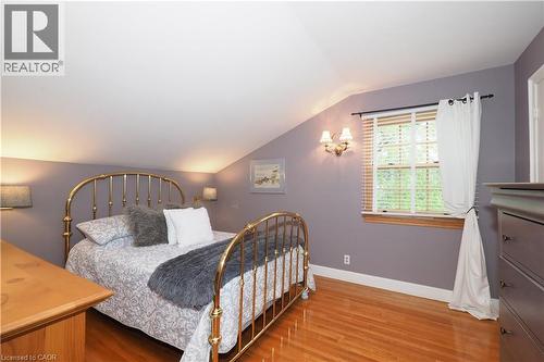 Room featuring sloped ceilings, wood-finish flooring, a double-hung window with blinds, and wall sconce lighting - 2023 Coronation Boulevard, Cambridge, ON - Indoor Photo Showing Bedroom