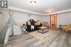 Spacious finished room featuring wood-finish flooring, recessed lighting, white paneled accent wall, and a wood-framed doorway - 