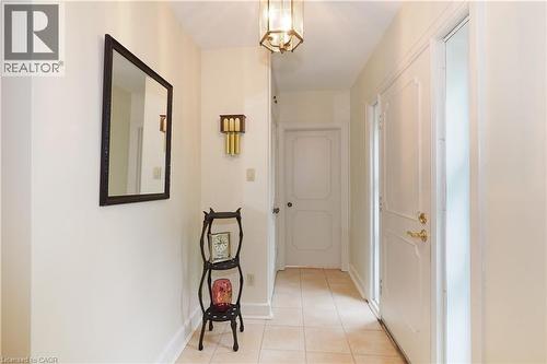 Entryway featuring neutral wall tones, tile flooring, a paneled entry door with brass hardware, and a ceiling-mounted lantern light fixture - 2023 Coronation Boulevard, Cambridge, ON - Indoor Photo Showing Other Room