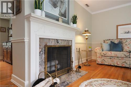 Ornate fireplace with a decorative white mantel, marble surround, and brass fire screen - 2023 Coronation Boulevard, Cambridge, ON - Indoor Photo Showing Living Room With Fireplace