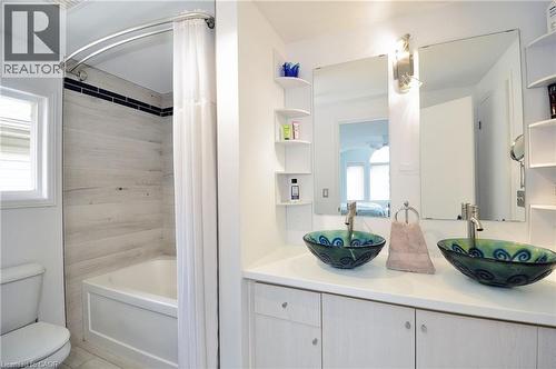 Dual vessel sinks with unique blue and green patterns, set on a white countertop with light wood-finish cabinetry - 12 Karalee Crescent, Cambridge, ON - Indoor Photo Showing Bathroom