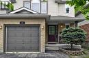 Brick and siding facade featuring an attached garage with a panel door, covered entryway, and an arched window on the upper level - 12 Karalee Crescent, Cambridge, ON  - Outdoor 
