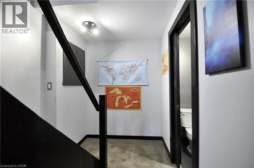 Staircase with dark-finish handrail, contemporary track lighting, light gray walls, and dark-finish baseboards - 12 Karalee Crescent, Cambridge, ON - Indoor Photo Showing Other Room