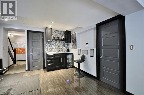 Wet bar featuring black cabinetry, a mosaic tile backsplash, and a built-in beverage cooler - 12 Karalee Crescent, Cambridge, ON - Indoor Photo Showing Other Room
