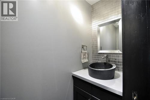 Modern vanity featuring a vessel sink, single-handle faucet, and white countertop - 12 Karalee Crescent, Cambridge, ON - Indoor