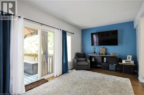 Living area featuring wood-finish flooring and a distinctive accent wall - 12 Karalee Crescent, Cambridge, ON - Indoor Photo Showing Bedroom