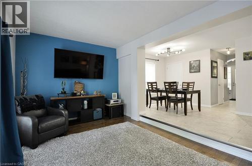 Open-concept living area featuring a prominent accent wall and wood-finish flooring - 12 Karalee Crescent, Cambridge, ON - Indoor Photo Showing Living Room