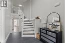 Elegant foyer featuring a curved staircase with white risers and dark treads, slate-look tile flooring, white balusters, and a recessed ceiling light - 27 Barbara Court, Hamilton, ON  - Indoor Photo Showing Other Room 