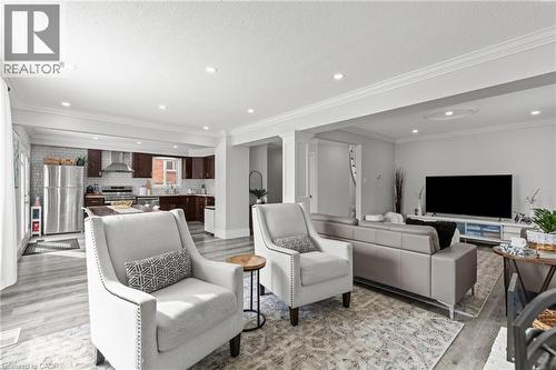 Open-concept living space featuring wood-finish flooring, recessed lighting, and crown molding - 27 Barbara Court, Hamilton, ON - Indoor Photo Showing Living Room